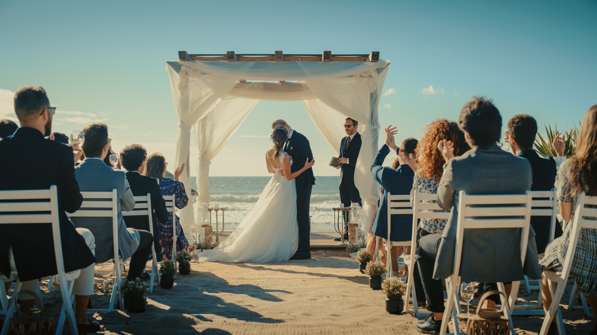Mae and Elliot sharing a kiss during their waterfront ceremony
